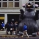 People and a giant mouse statue in front of the building