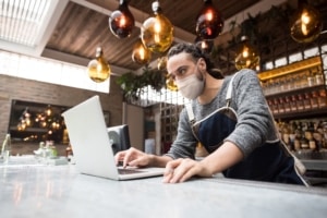 Man leans over computer with widened eyes