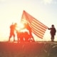 Soldiers raise American flag before a golden sunset